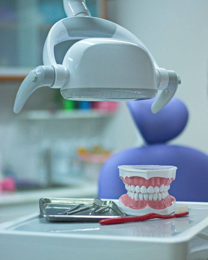 A dental chair with a teeth model and instruments ready for a check-up